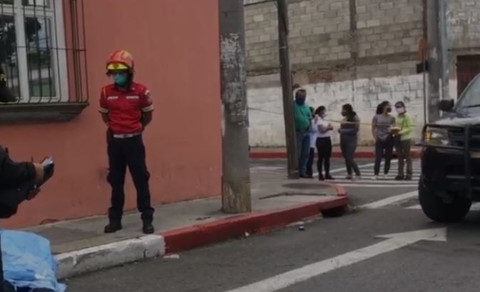Bombero observa cadáver de hombre que murió baleado en la zona 5 de la capital. (Foto Prensa Libre: Amílcar Montejo). 