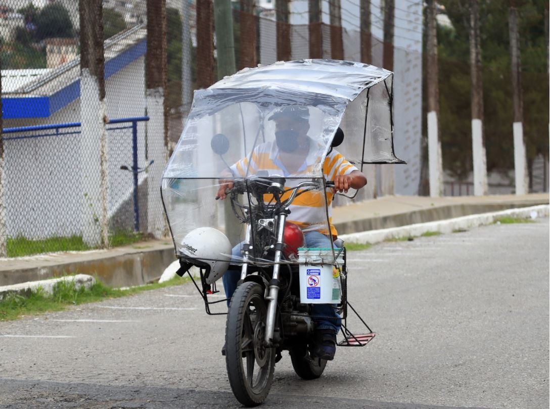 Un motorista acondicionó su motocicleta para prevenir contagios de covid-19, mientras presta servicios de traslado de personas. (Foto Prensa Libre: Óscar Rivas)