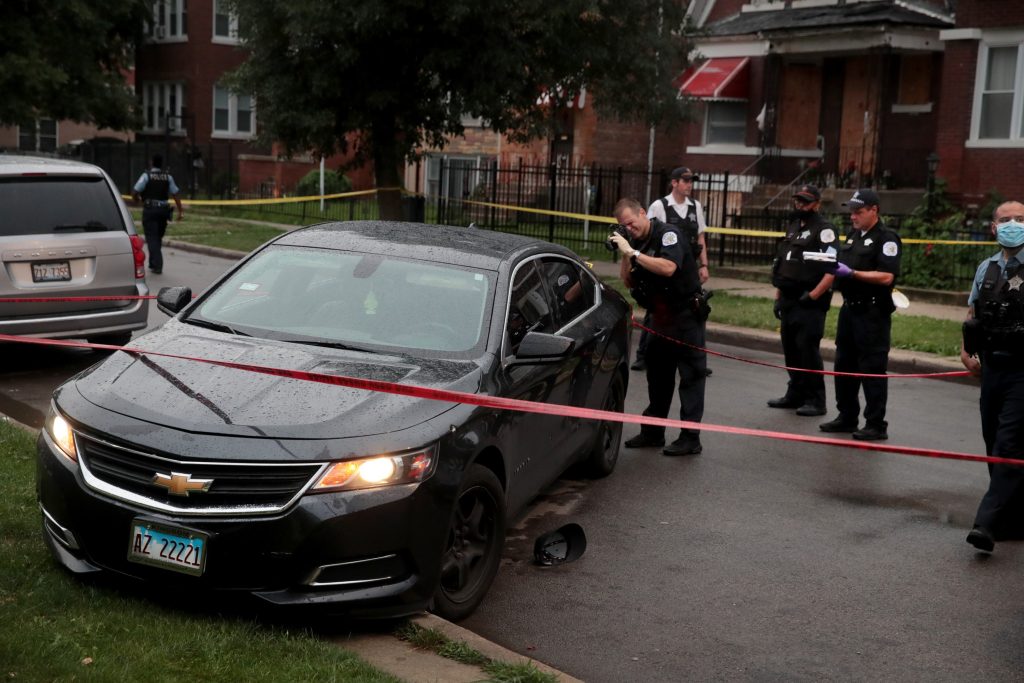 CHICAGO, ILLINOIS - JULY 21: Police investigate the scene of a shooting in the Auburn Gresham neighborhood on July 21, 2020 in Chicago, Illinois. At least 14 people were transported to area hospitals after several gunmen, believed to be in this bullet-riddled car, opened fire on mourners standing outside a funeral home. The car crashed and the occupants fled after mourners returned fire. More than 2000 people have been shot and more than 400 have been murdered in Chicago so far this year.   Scott Olson/Getty Images/AFP
== FOR NEWSPAPERS, INTERNET, TELCOS & TELEVISION USE ONLY ==