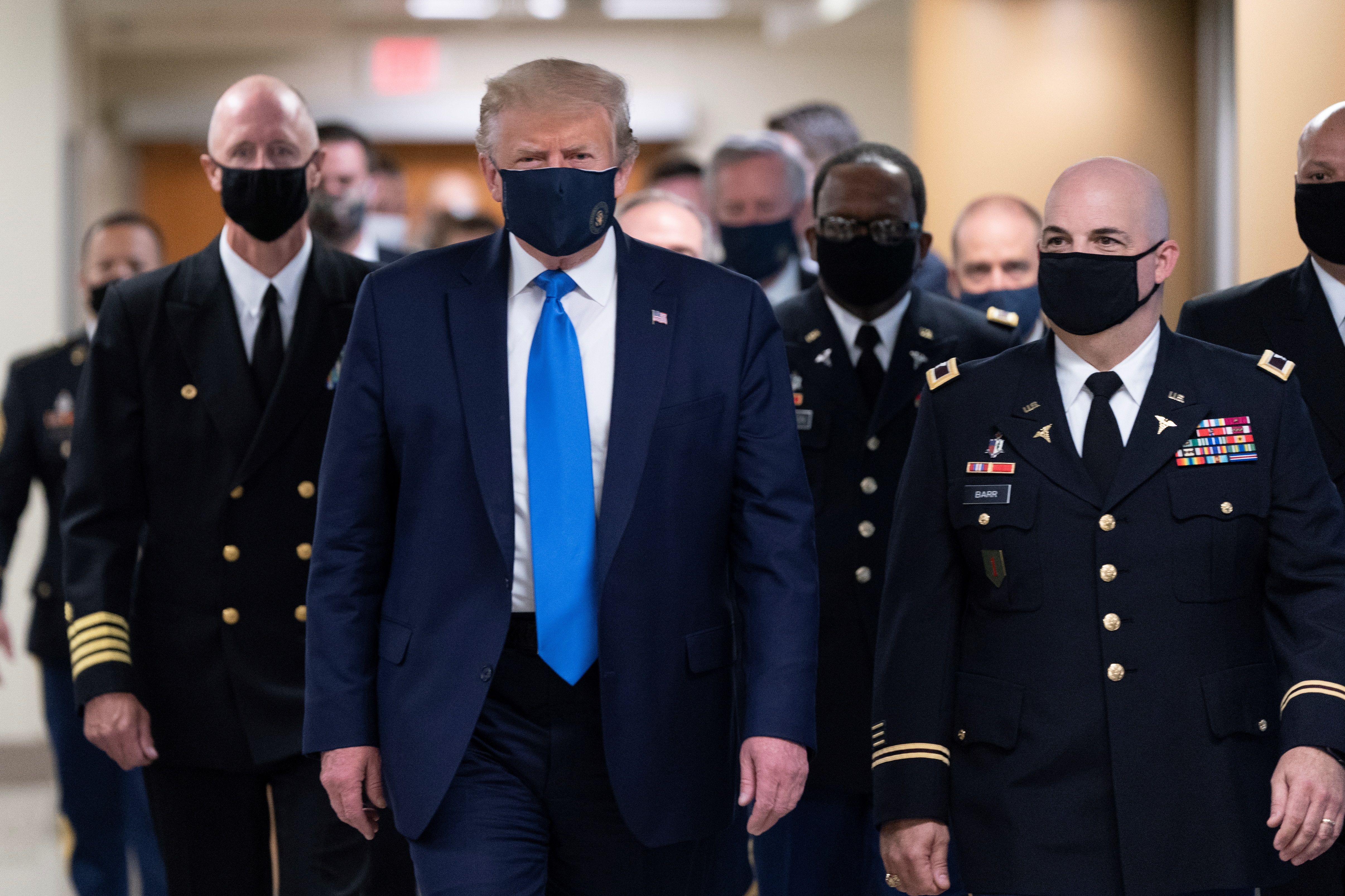 El presidente de los Estados Unidos, Donald J. Trump (C), usa una mascarilla a su llegada para visitar a militares heridos y a trabajadores de atención médica de coronavirus de primera línea en el Centro Médico Nacional Militar Walter Reed en Bethesda, Maryland, EE. UU. (Foto Prensa Libre: EFE)