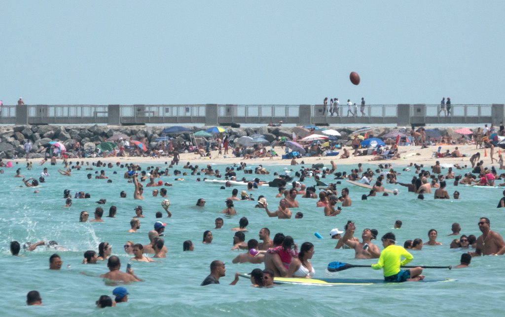 Bañistas gozan de las playas en Miami, mientras las camas en hospitales escasean por escalada de contagios. (Foto Prensa Libre: EFE)