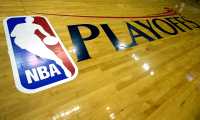 (FILES) In this file photo taken on April 27, 2013, the NBA and Playoffs logo is seen on the court before the game between the Oklahoma City Thunder and Houston Rockets in Houston, Texas. NOTE TO USER: User expressly acknowledges and agrees that, by downloading and or using this photograph, User is consenting to the terms and conditions of the Getty Images License Agreement.   Scott Halleran/Getty Images/AFP. - There have been 25 NBA players who were positive for COVID-19 since testing began last week ahead of the planned season restart, the league and players union announced on July 2, 2020. (Photo by SCOTT HALLERAN / GETTY IMAGES NORTH AMERICA / AFP)