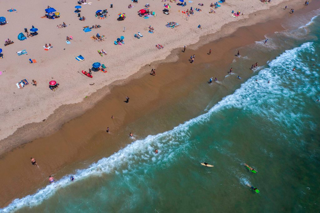 Expertos dicen que la reapertura del comercio y playas en California aceleraron los contagios. (Foto Prensa Libre: AFP)