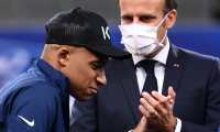 French President Emmanuel Macron (R) applauds as Paris Saint-Germain's French forward Kylian Mbappe walks with crutches onto a platform for the trophy ceremony after winning the French Cup final football match between Paris Saint-Germain (PSG) and Saint-Etienne (ASSE), at The Stade de France in Saint-Denis, outside Paris on July 24, 2020. - Paris Saint-Germain coach Thomas Tuchel said "everyone is worried" after Kylian Mbappe hobbled off in the first half of The French Cup final with an ankle injury after a dreadful tackle by Saint-Etienne captain Loic Perrin. (Photo by FRANCK FIFE / AFP)