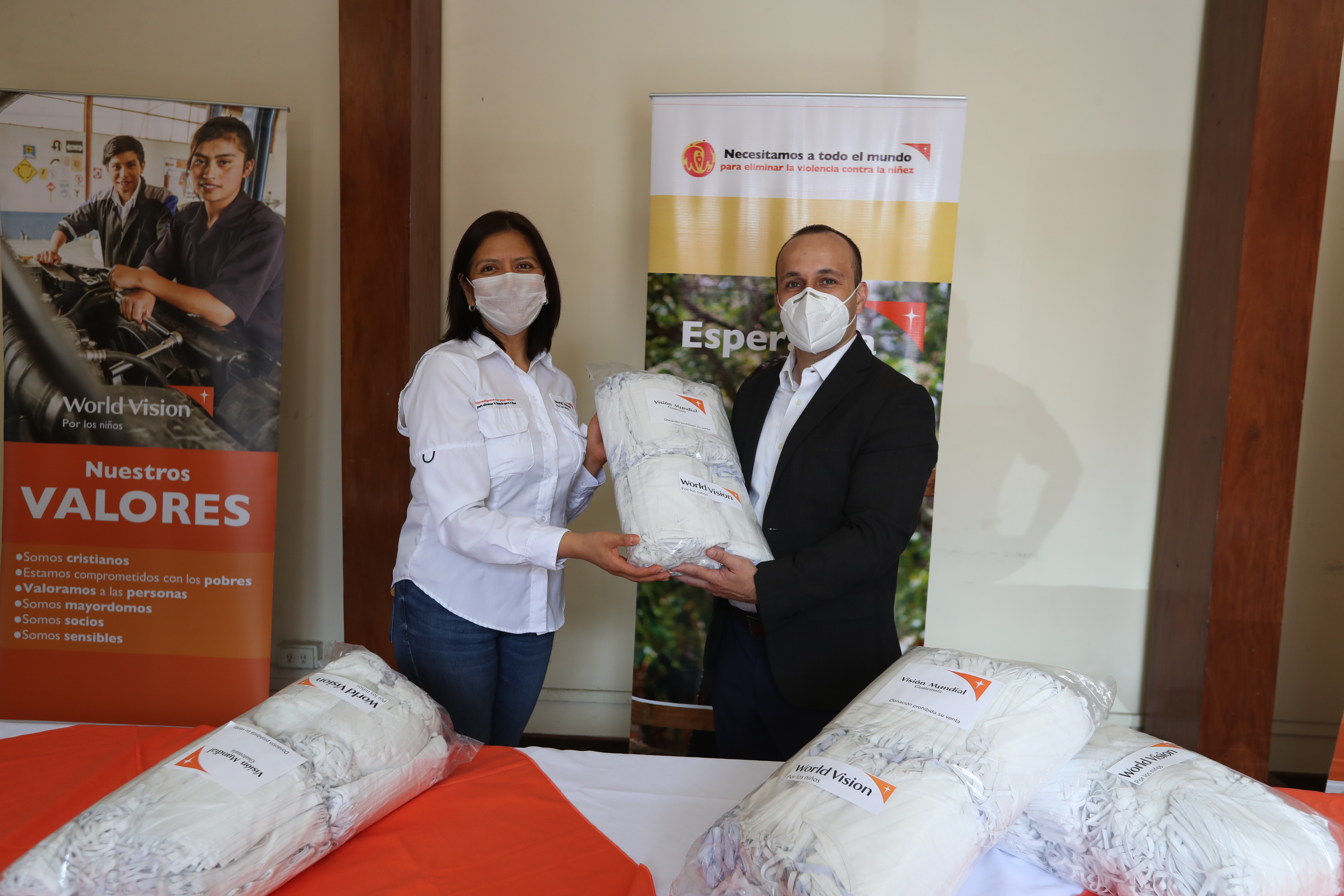 Ana Meléndez, directora de marketing y comunicaciones de World Vision, hace la entrega de las mascarillas a Gunther Wellman. (Foto Prensa Libre: Norvin Mendoza)