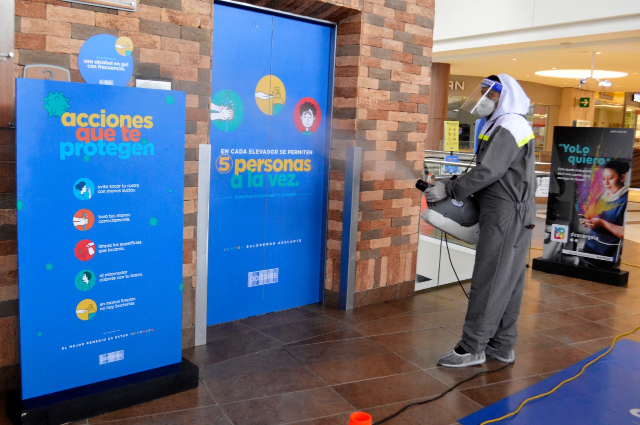 Un empleado desinfecta los elevadores de un centro comercial para garantizar la salubridad al momento de recibir visitantes. (Foto Prensa Libre: María René Gaytán)