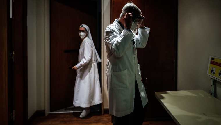 Un médico se coloca una máscara de protección en la clínica Mater Dei en la ciudad de Buenos Aires, Argentina, que permite la despedida entre familiares y pacientes terminales con coronavirus. (Foto Prensa Libre: EFE)