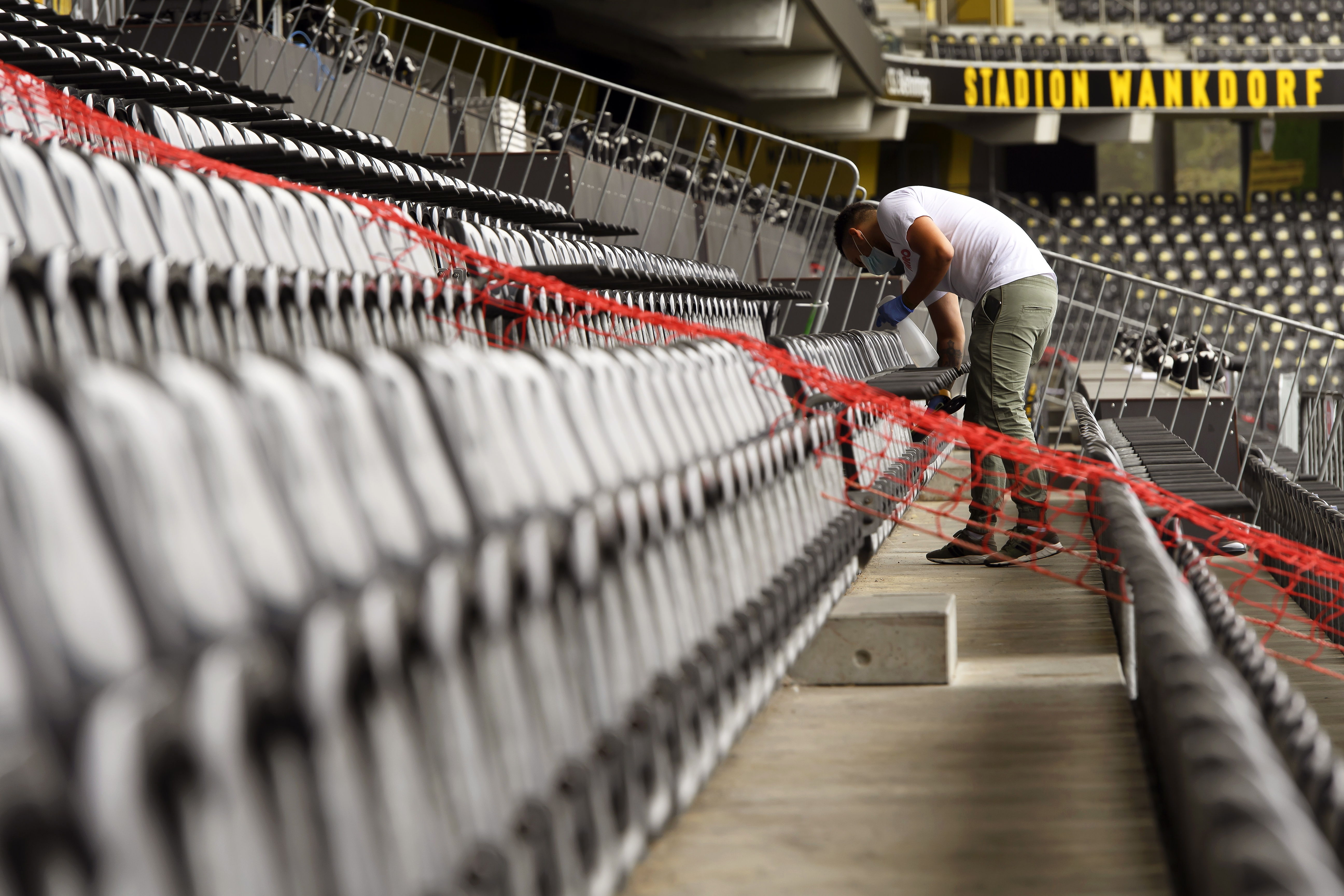 Bern (Switzerland), 25/08/2020.- A volunteer disinfects spectator seats during a training session of BSC Young Boys at Wankdorf stadium in Bern, Switzerland, 25 August 2020. BSC Young Boys will face KI Klaksvik in their UEFA Champions League second qualifying round soccer match on 26 August 2020. (Liga de Campeones, Suiza) EFE/EPA/ANTHONY ANEX