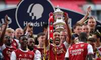 Arsenal's Gabonese striker Pierre-Emerick Aubameyang holds the winner's trophy as the team celebrates victory after the English FA Cup final football match between Arsenal and Chelsea at Wembley Stadium in London, on August 1, 2020. - Arsenal won the match 2-1. (Photo by Adam Davy / POOL / AFP) / NOT FOR MARKETING OR ADVERTISING USE / RESTRICTED TO EDITORIAL USE