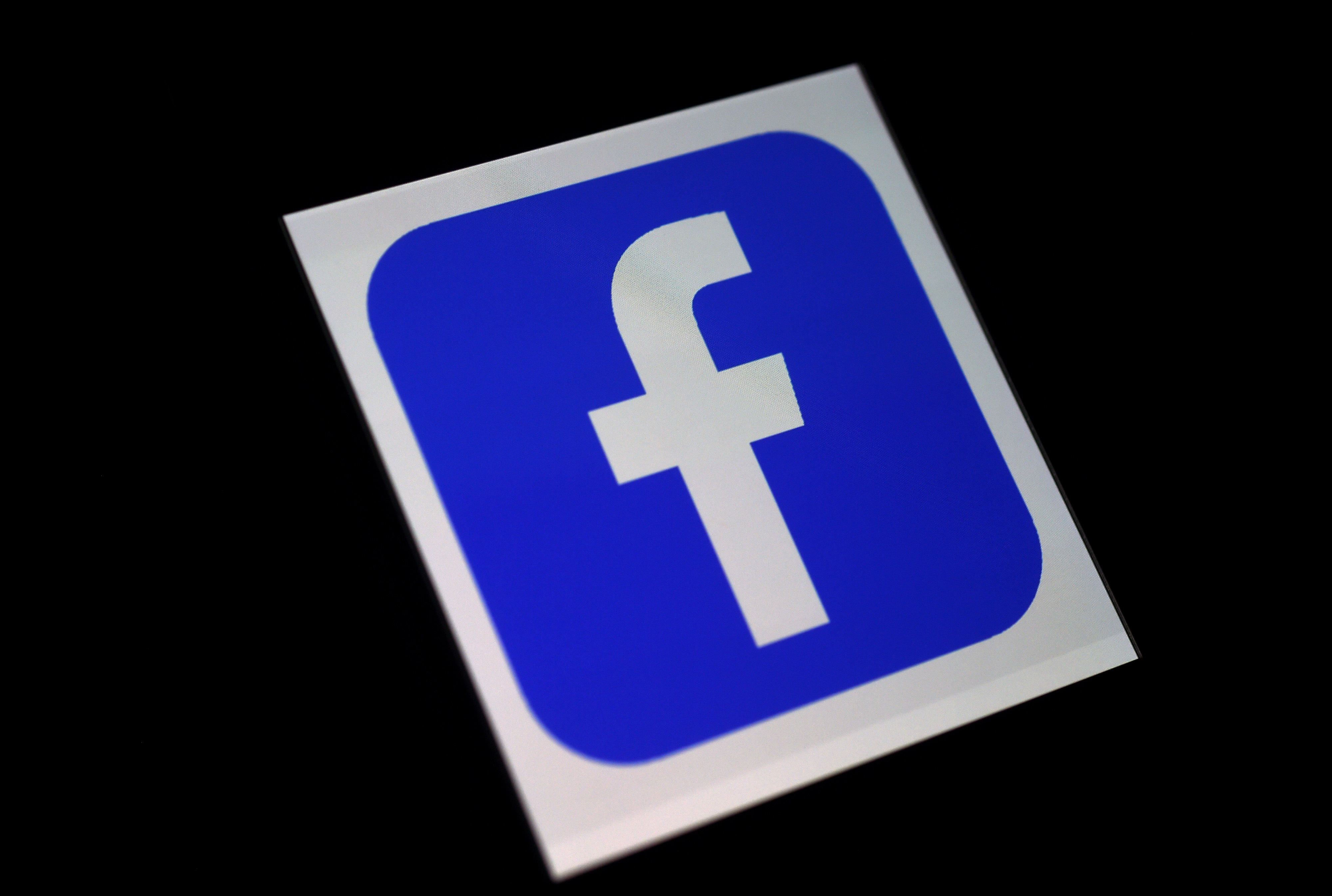 (FILES) In this file illustration photo taken on March 25, 2020, a Facebook App logo is displayed on a smartphone in Arlington, Virginia. - Facebook on August 26, 2020, said a mobile software update about to be released by Apple will slash revenue for developers relying on its in-app ad network. (Photo by Olivier DOULIERY / AFP)