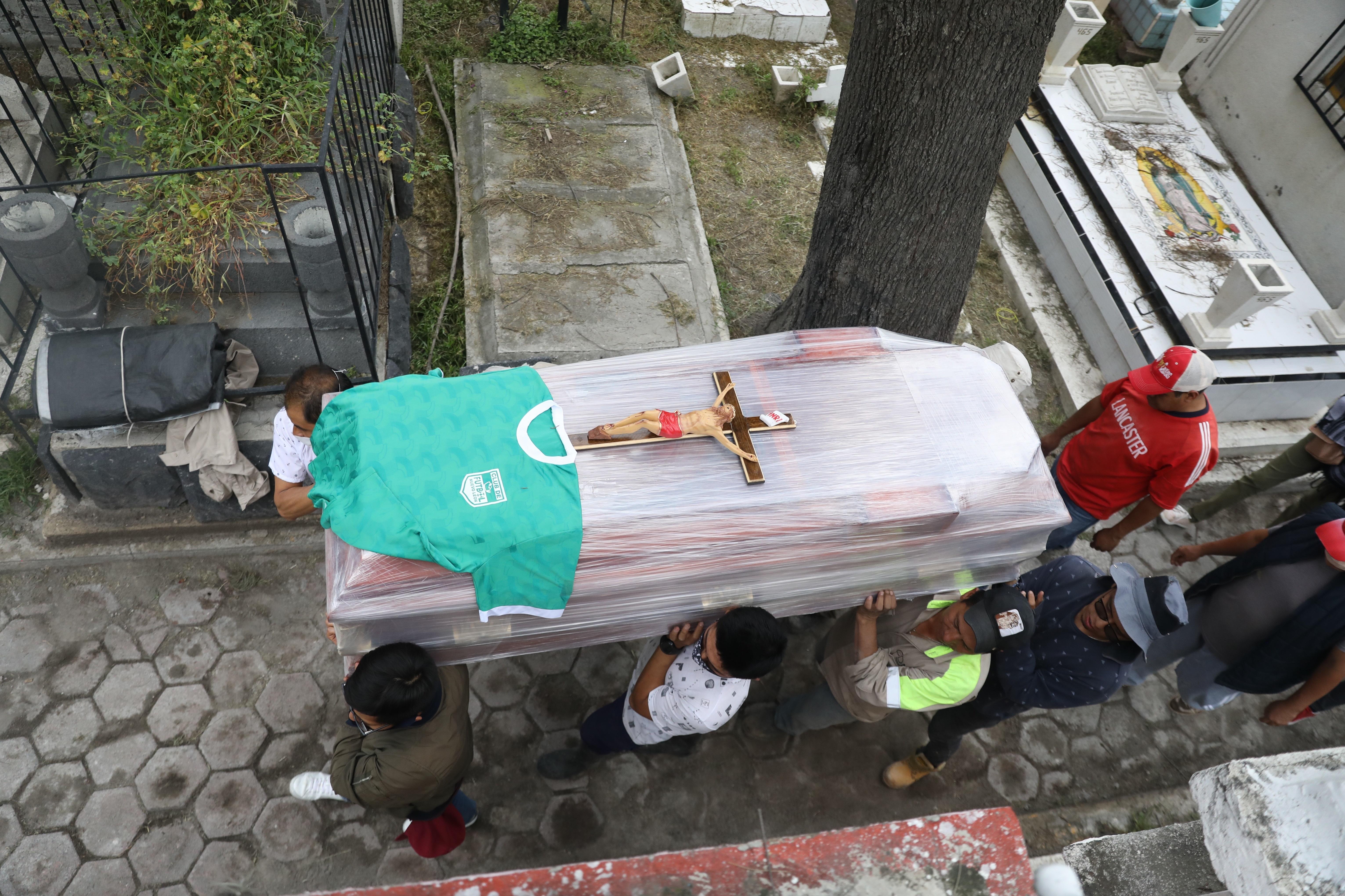 Familiares de Juan Pueblita, quien murió de coronavirus, le dan el último adiós en el panteón de Tláhuac en la Ciudad de México. (Foto Prensa Libre: EFE)