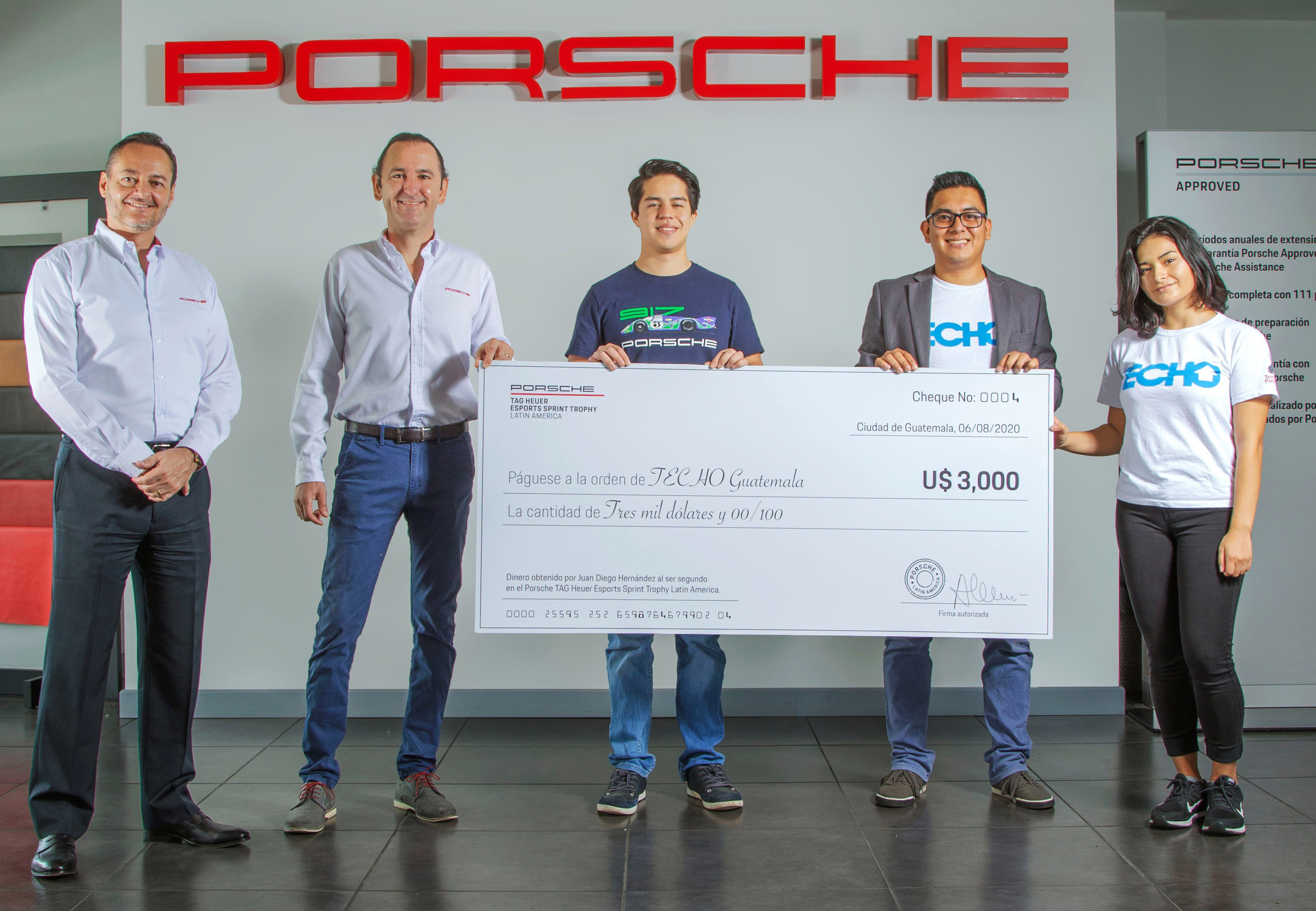 Juan Diego Hernández (al centro) y Directivos de Grupo Los Tres realizaron la entrega del dinero a Techo Guatemala. (Foto Prensa Libre: cortesía Porsche Center Guatemala)