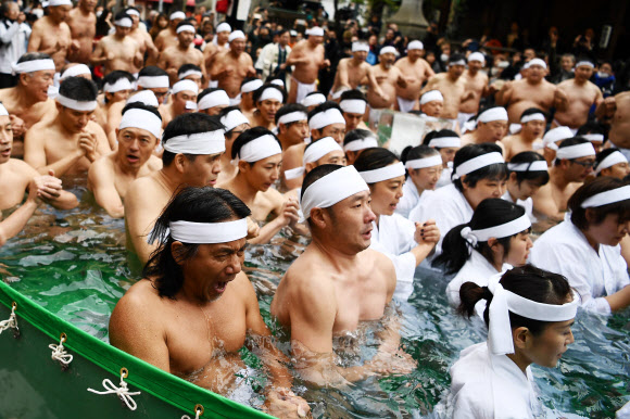 Creyentes sintoístas toman un baño de agua fría durante un ritual de año nuevo en Tokio, el 11 de enero de 2020. (Foto Prensa Libre: Agence France-Presse)