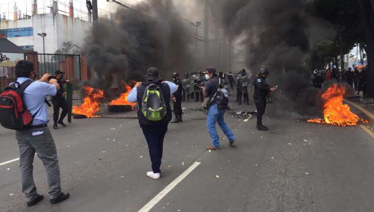 Agentes antidisturbios de la PNC retiran el bloqueo en la avenida Petapa y habilitan el paso vehicular. (Foto Prensa Libre: ) 