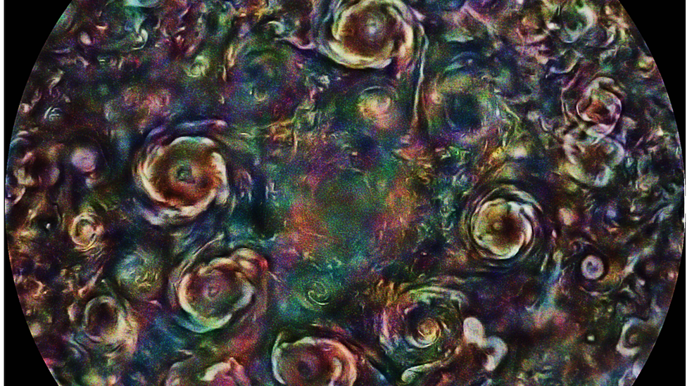 La imagen retocada con colores llamativos muestra varias tormentas en Júpiter.