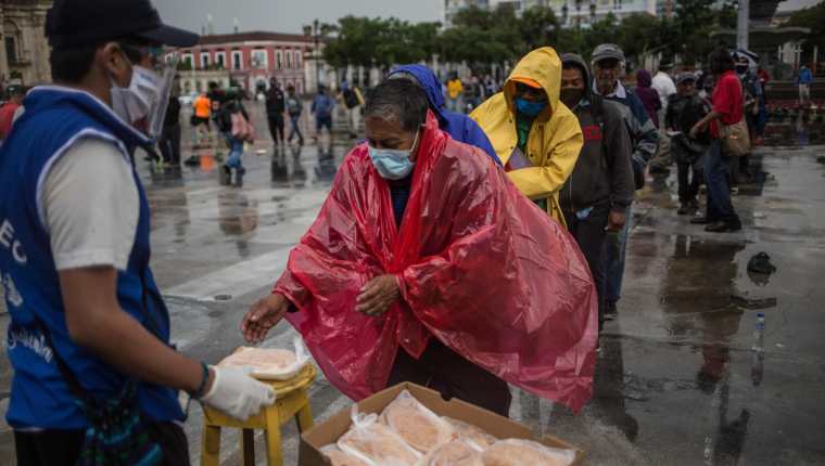 Un hombre recibe un almuerzo gratuito en la Plaza de la Constitución este 10 de septiembre por parte del proyecto La Olla Comunitaria, quienes han colaborado durante la crisis del coronavirus. Fotografía: Prensa Libre. 