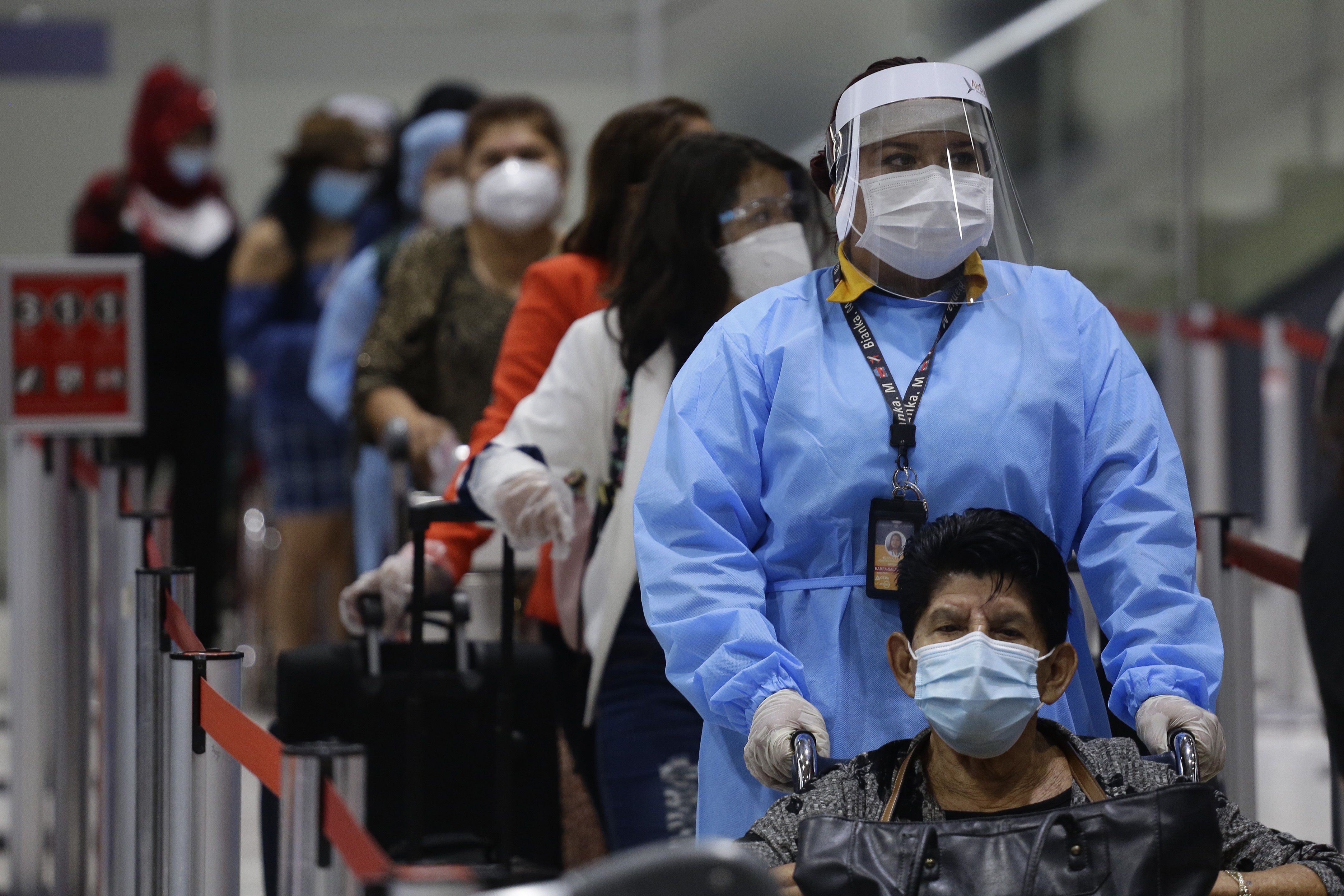 Viajeros hacen fila en el Aeropuerto Internacional San Óscar Arnulfo Romero y Galdámez, en San Luis Talpa, El Salvador, donde las actividades regresan a la normalidad en medio de un repunte de casos de coronavirus. (Foto Prensa Libre: EFE)