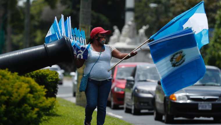 Lucía López camina en la avenida la Reforma, zona 10; vendiendo banderas durnate ocho horas al día. (Foto Prensa Libre: Esbin García)  
