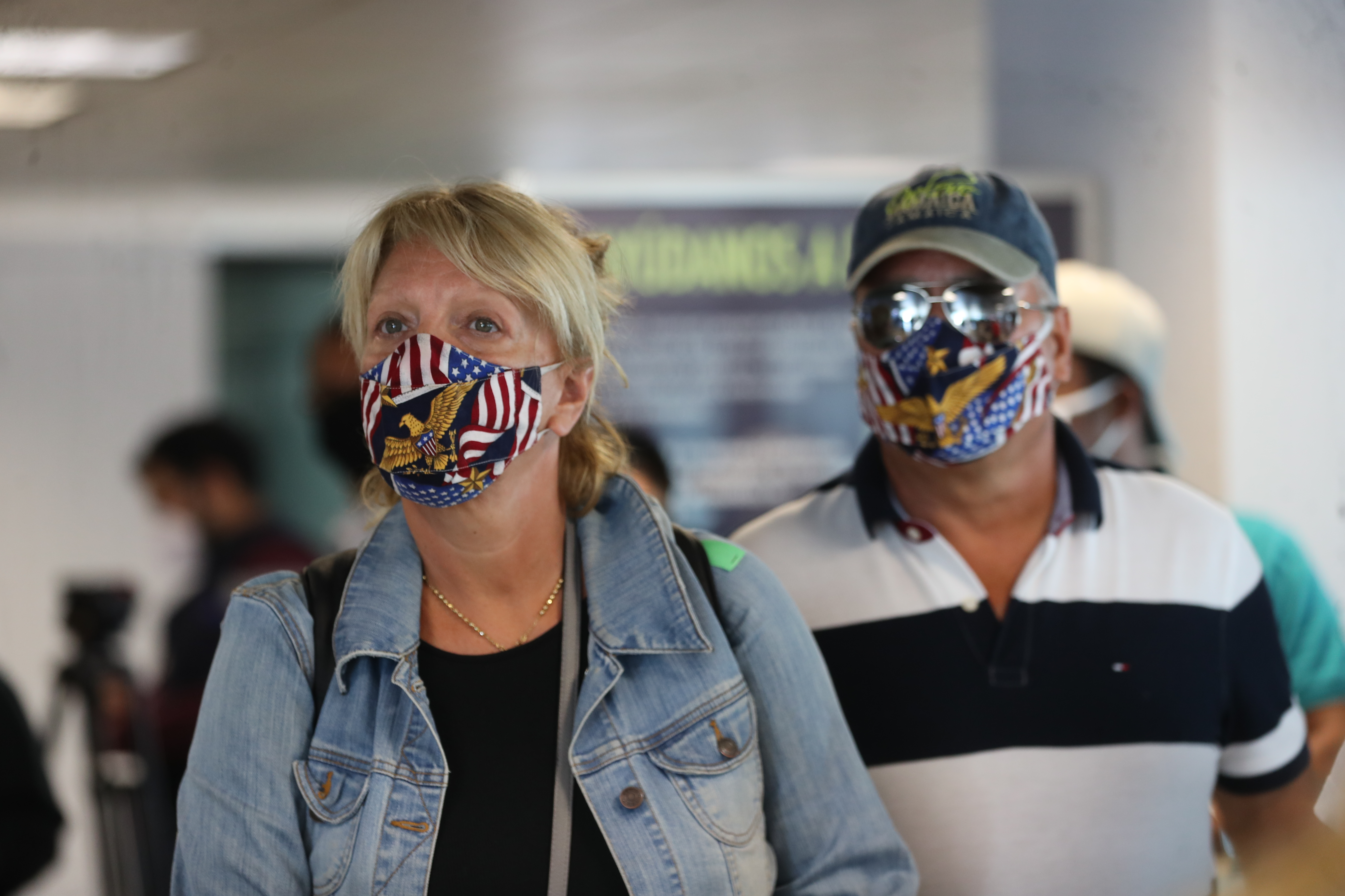 Una pareja utiliza mascarillas para protegerse del coronavirus mientras esperan para abordar un avión en un aeropuerto. (Foto Prensa Libre: Erick Avila)