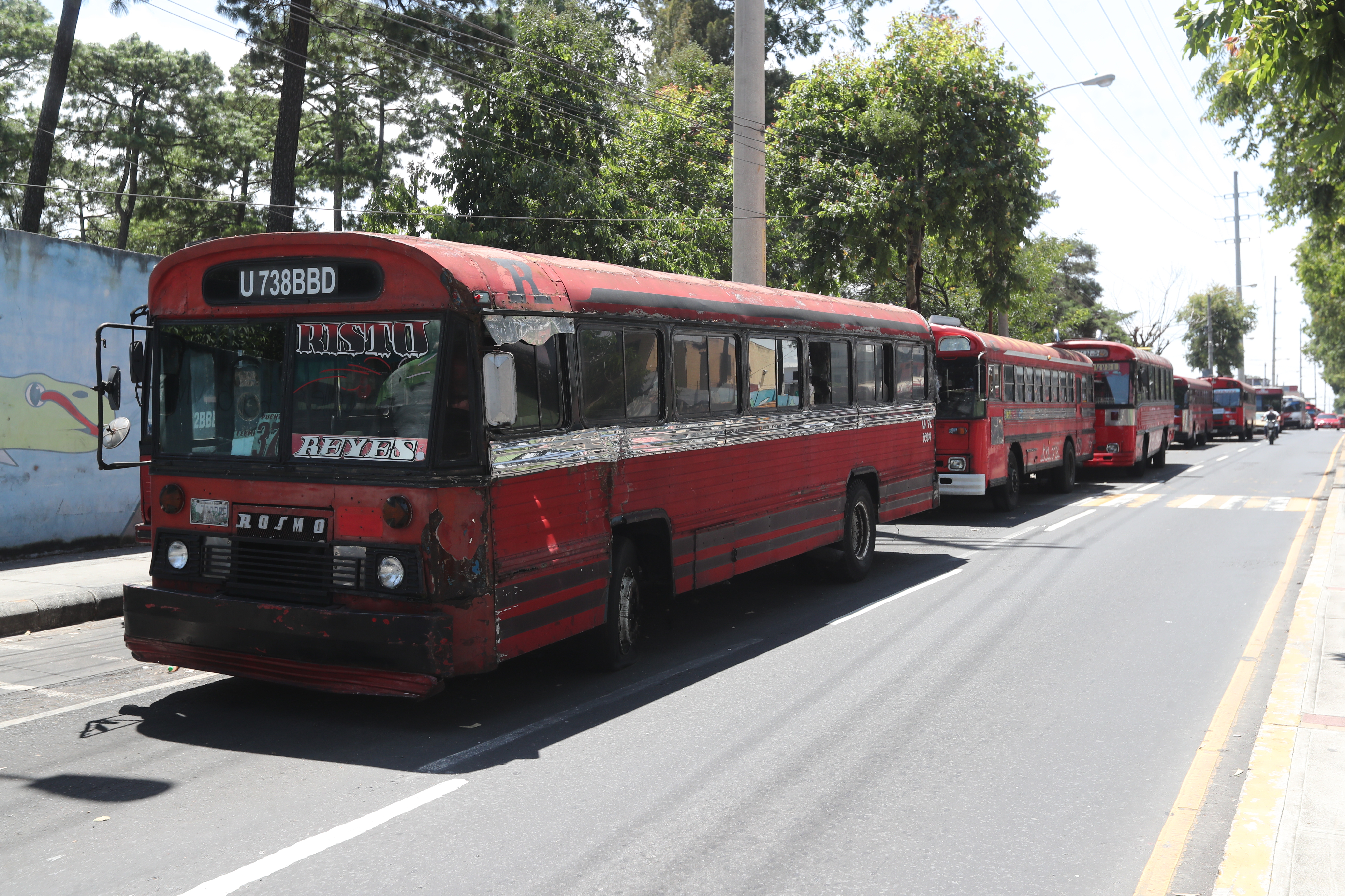 Buses rojos estacionados en una de las calles de la zona 7 ante la falta de acuerdos con el gobierno para comenzar a circular. Fotografía: Prensa Libre. 

