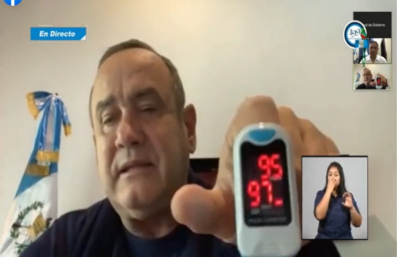 Alejandro Giammattei muestra un oxímetro con el registro de 95% de pulso y 97% de saturación. 