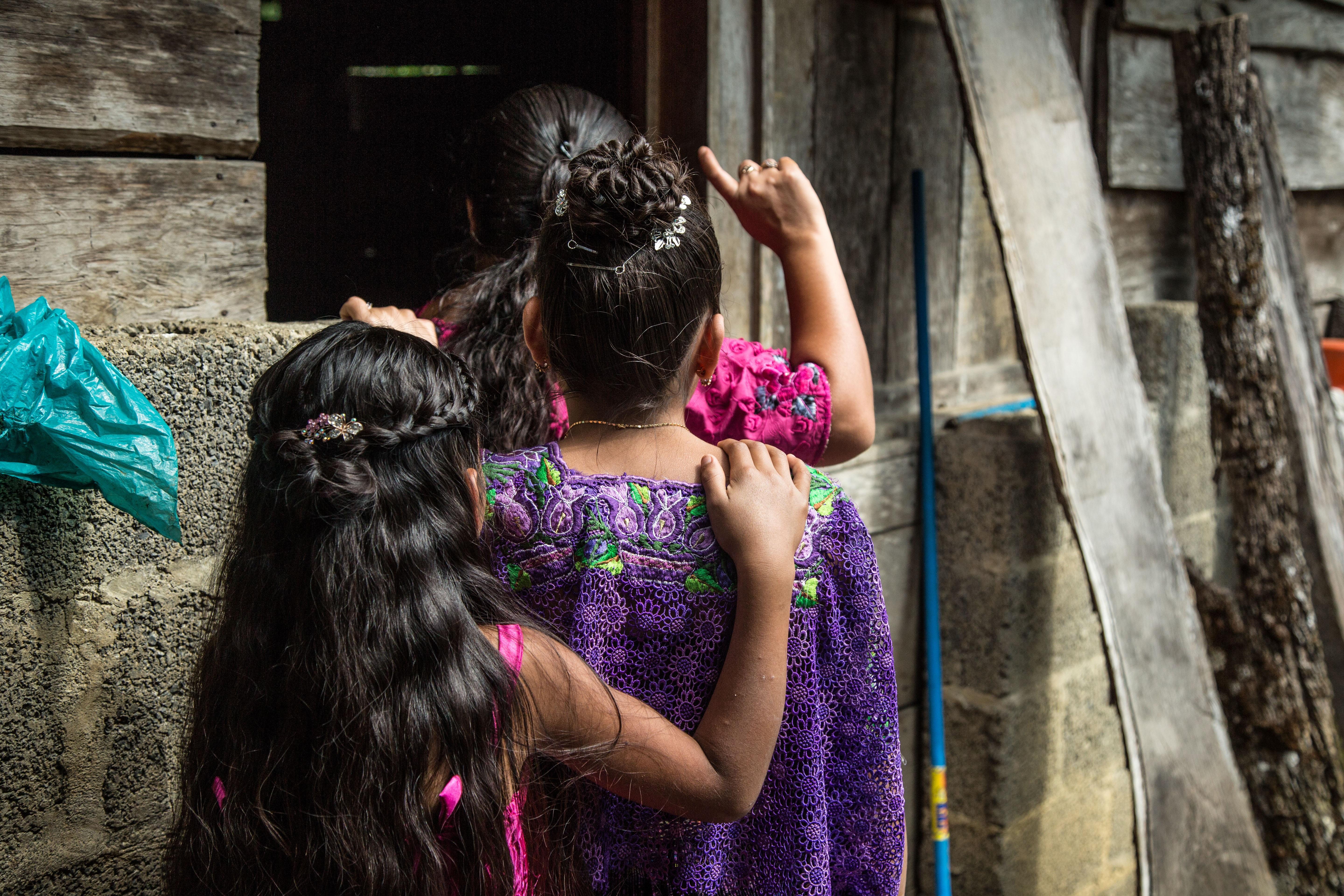 La hermana pequeña de Marta la abraza durante la celebración de su cumpleaños 15 en una aldea de Cobán, el 5 de octubre de 2020, en Cobán. Marta es una de las 22 niñas que acusan a maestros y trabajadores del ministerio de educación de Guatemala por violaciones sexuales. (Foto Prensa Libre: EFE)
