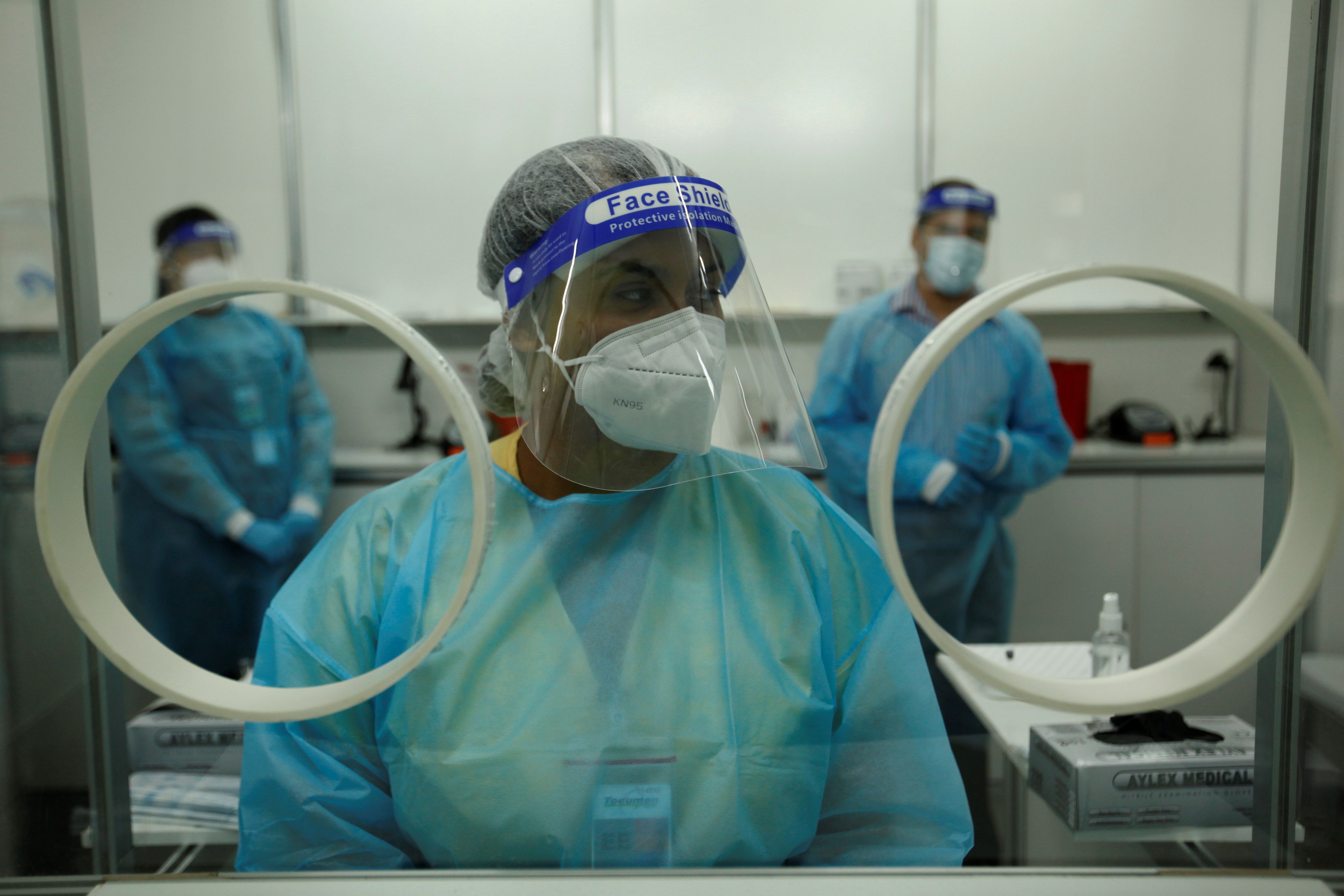 Personal médico privado realiza pruebas de hisopados para detectar covid-19. (Foto Prensa Libre: EFE)