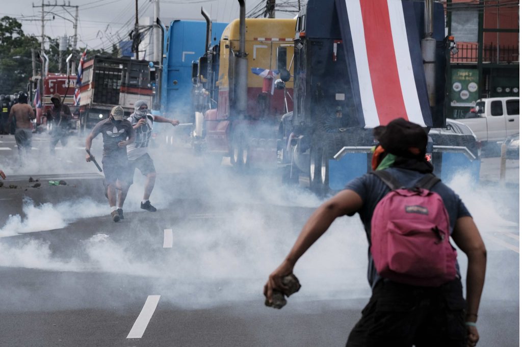 AME911. SAN JOSÉ (COSTA RICA), 12/10/2020.- Manifestantes chocan hoy con efectivos antidisturbios durante una protesta en contra de un eventual acuerdo del Gobierno costarricense con el Fondo Monetario Internacional (FMI), en inmediaciones de la Casa Presidencial, en San José (Costa Rica). Un grupo de manifestantes y la Fuerza Pública de Costa Rica se enfrentaron este lunes en las inmediaciones de la Casa Presidencial, en donde culminó una protesta en contra de un eventual acuerdo del Gobierno de Carlos Alvarado con el FMI. EFE/Jeffrey Arguedas