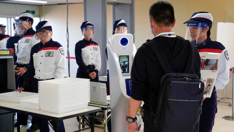 Personal de seguridad de los Juegos Olímpicos de Tokio 2020 durante las pruebas de los protocolos contra el coronavirus. (Prensa Libre: EFE)