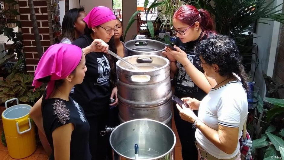 Mujeres cerveceras en Cali, Colombia, elaborando una cerveza American Pale Ale con adición de mora, a la vista de público interesado. 