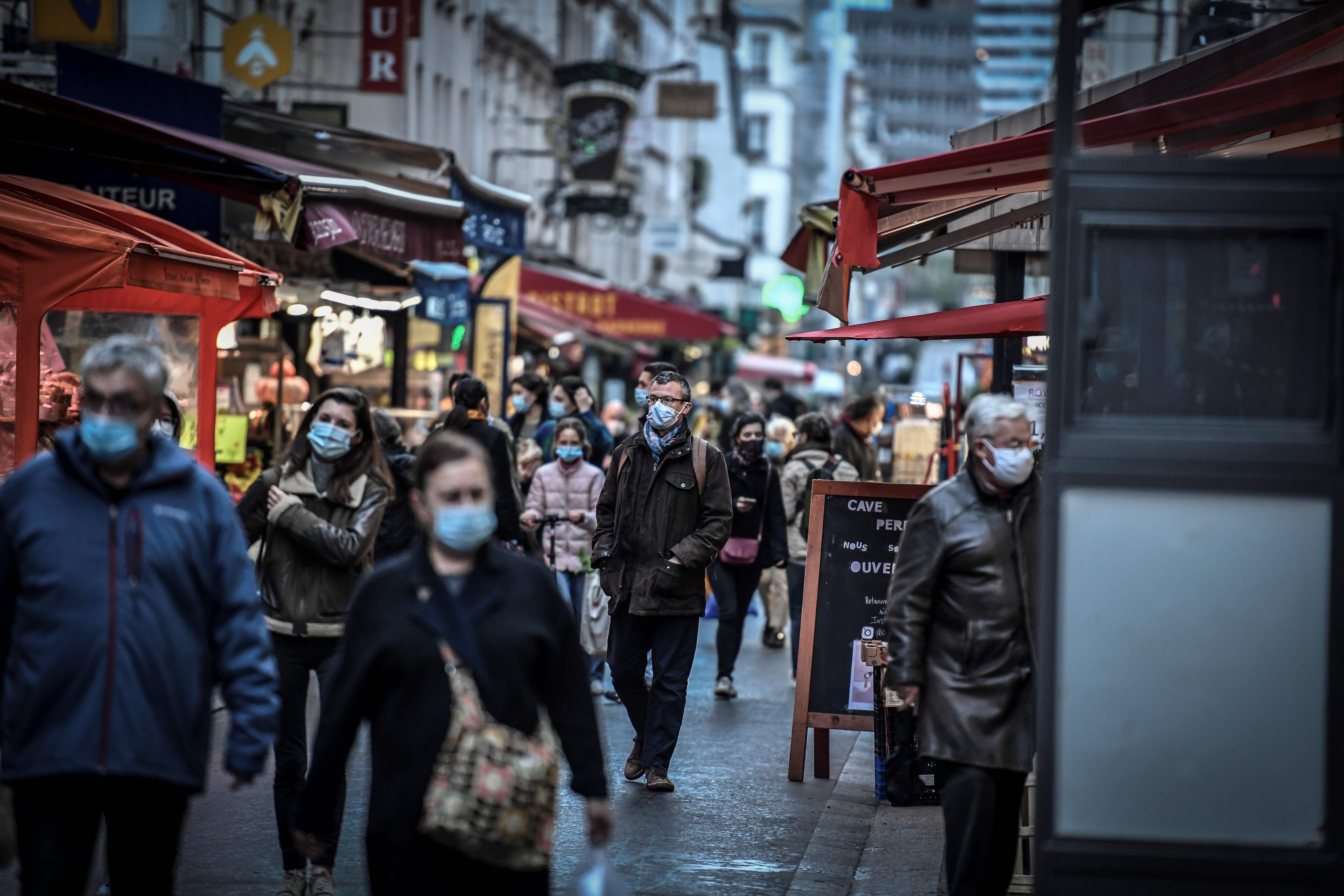 Personas portan mascarillas en París, Francia