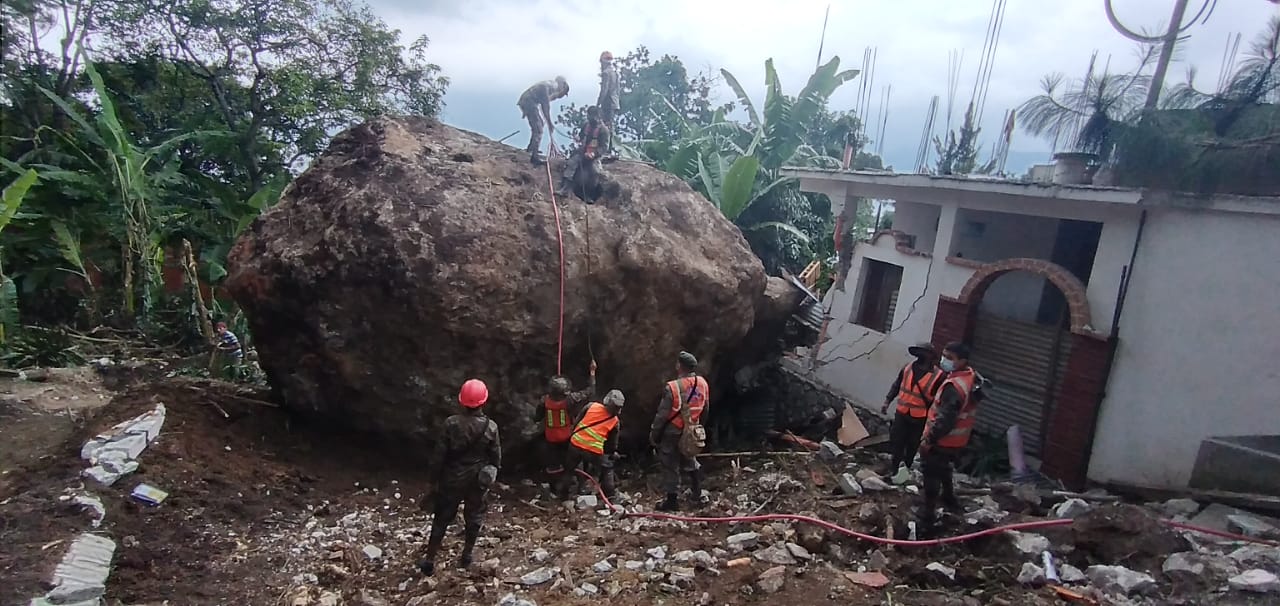 Personal de la Conred y del Ejército de Guatemala trabajan para retirar la enorme roca que cayó en viviendas de San Marcos La Laguna, Sololá. (Foto Prensa Libre: Conred)