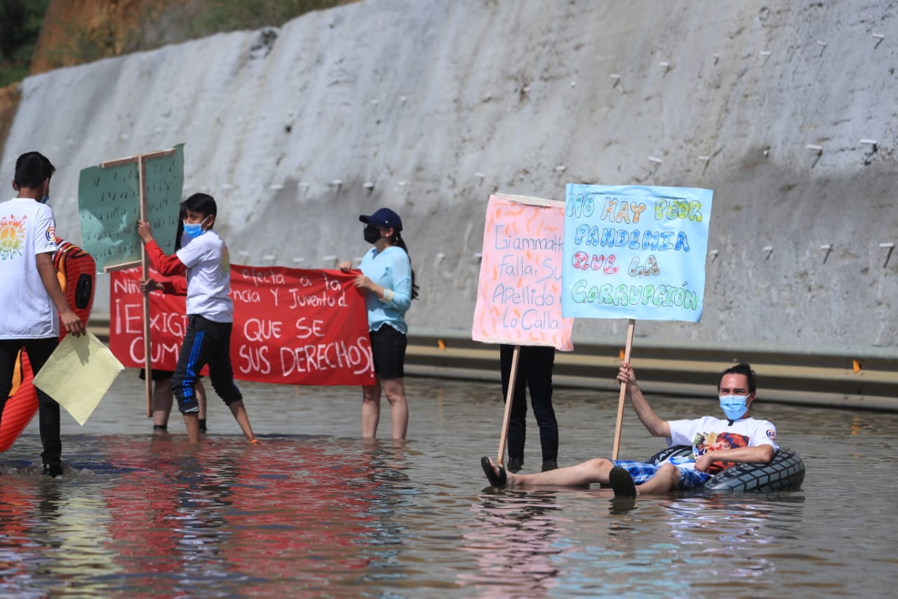 Con carteles, flotadores y pelotas de playa, jóvenes manifiestan contra corrupción en la obra del Libramiento de Chimaltenango que tiene tramos inundados. (Foto, Prensa Libre: Juan Diego González). 