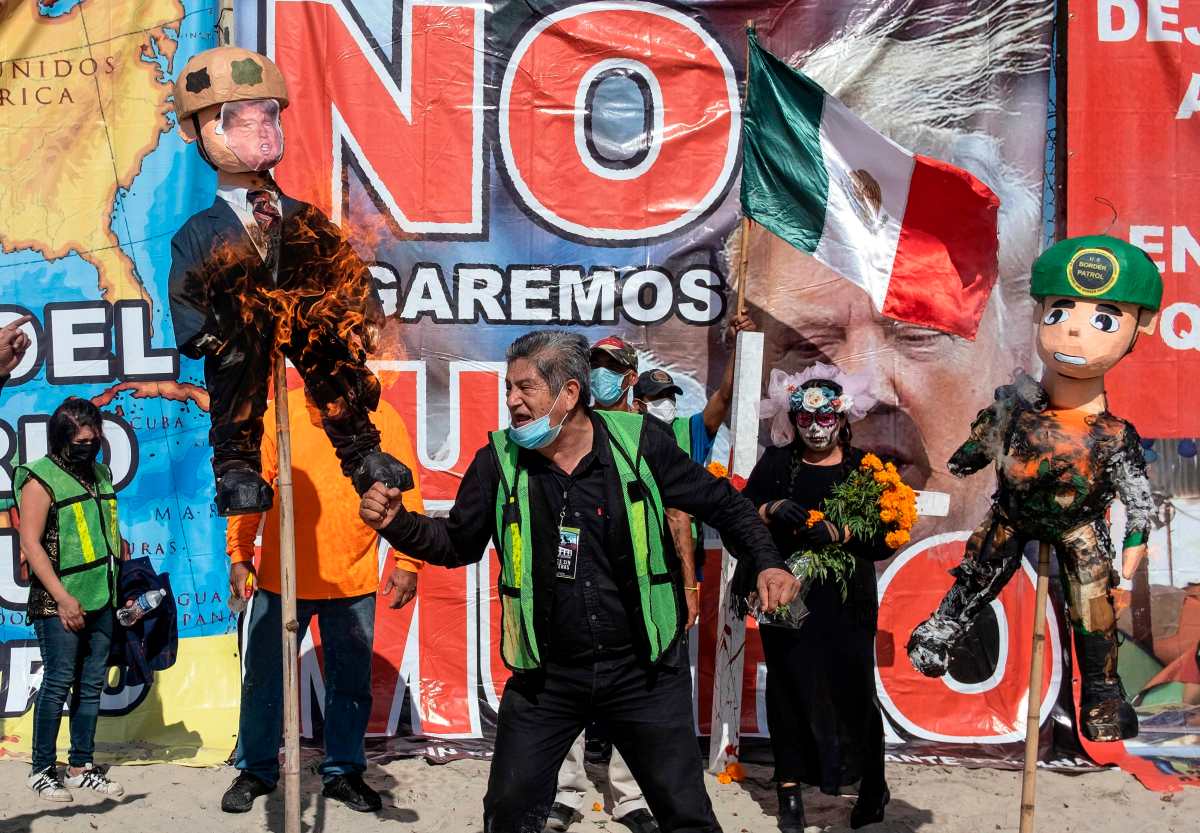 Migrantes queman figuras de Donald Trump para denunciar abusos en Tijuana