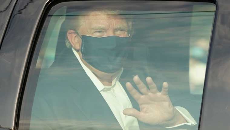 Donald Trump saluda desde el vehículo a sus partidarios que se encuentran afuera del hospital militar Walter Reed. (Foto Prensa Libre: AFP) 