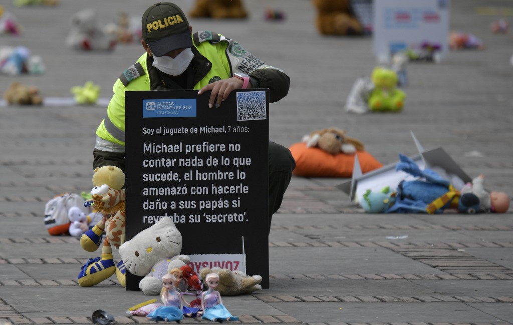 Un policía observa algunos de los peluches colocados como protesta en Colombia. (Foto Prensa Libre: AFP)