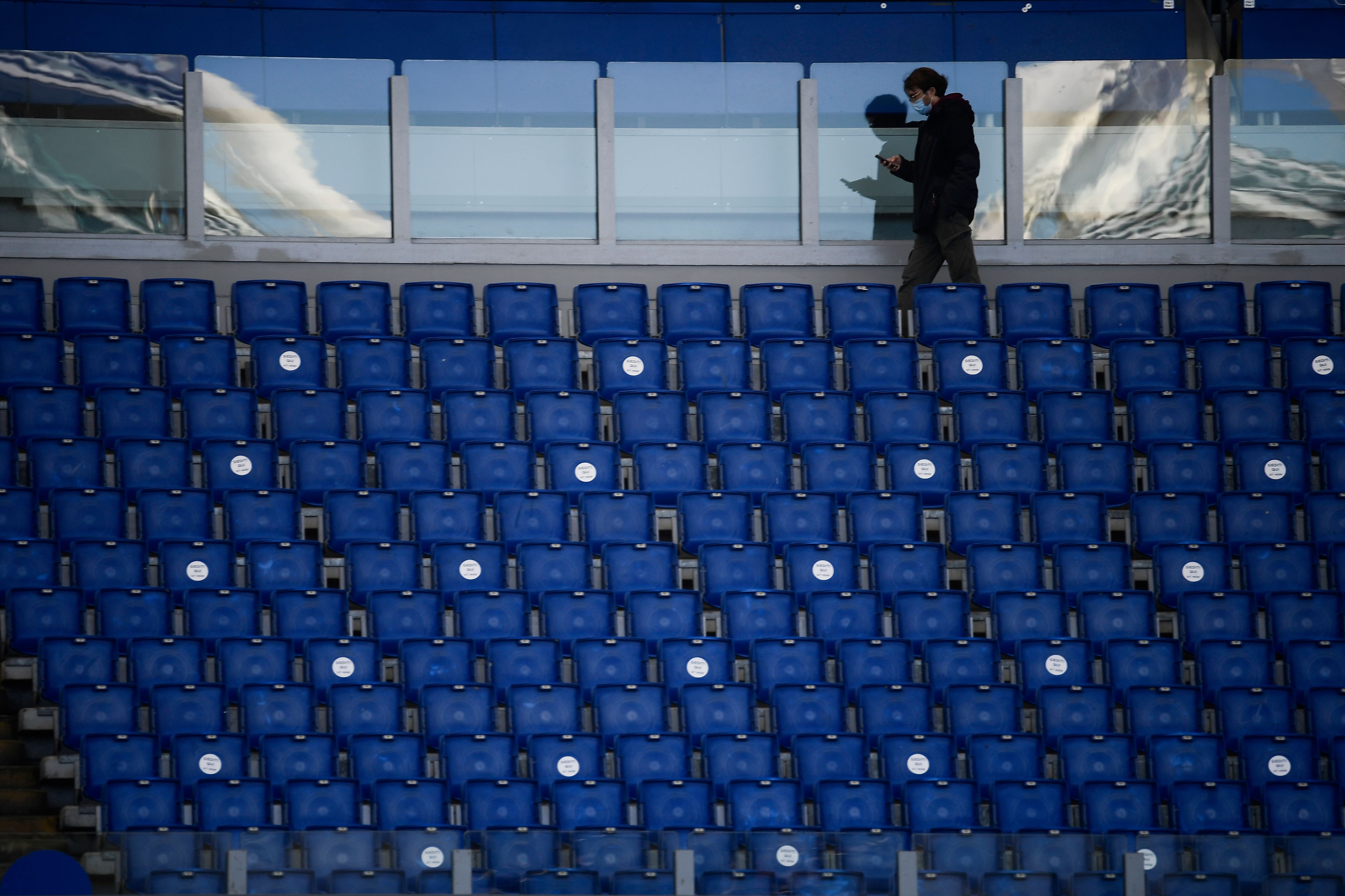 A man walks between the empty seats ahead of the Italian Serie A football match between Lazio (SSL) and Juventus (JFC) , at the Olympic stadium in Rome on November 8, 2020. (Photo by Filippo MONTEFORTE / AFP)