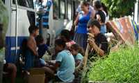 People prepare to be evacuated from banana fields onboard a minibus in La Lima municipality, Cortes department, Honduras, ahead of the arrival of Hurricane Iota on November 15, 2020. - Hurricane Iota is forecast to strengthen to an "extremely dangerous" Category Four by the time it makes landfall in Central America on Monday, the US National Hurricane Center warned, two weeks after powerful storm Eta devastated much of the region and left more than 200 people dead or missing. (Photo by Orlando SIERRA / AFP)
