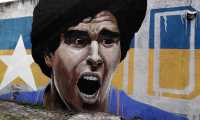 View of murals depicting Argentinian football legend Diego Maradona at La Boca neighborhood, in Buenos Aires on November 25, 2020, on the day of his death. (Photo by ALEJANDRO PAGNI / AFP)