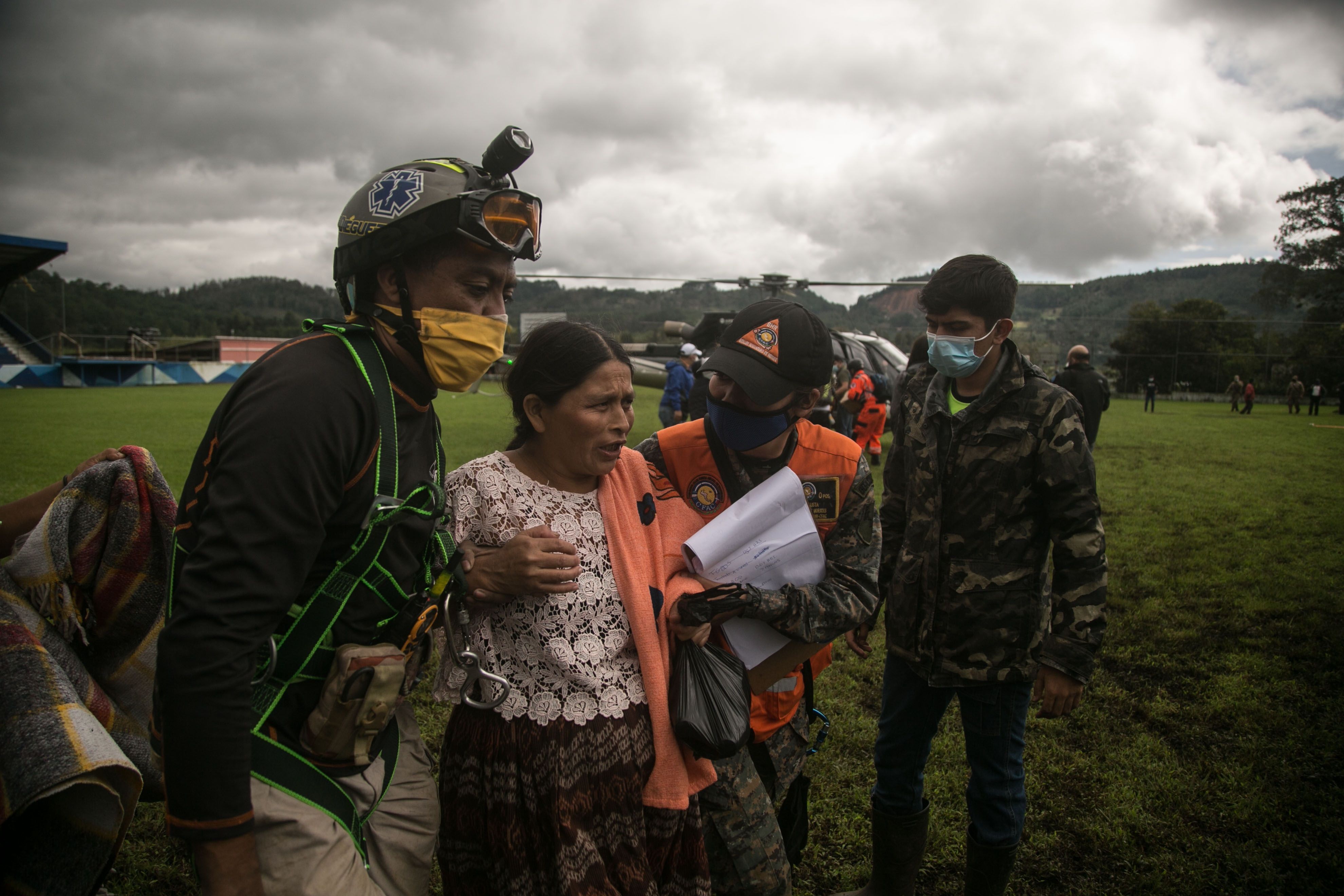 Socorristas hablan con una mujer luego de rescatarla en la zona del desastre donde se estima que decenas de personas murieron por una alúd provocado el pasado jueves por el paso de la tormenta Eta, en la aldea Quejá, en San Cristóbal Verapaz (Foto Prensa Libre: EFE)