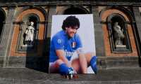 Naples (Italy), 27/11/2020.- A picture of Diego Armano Maradona is attached to the facade of the Royal Palace in Piazza del Plebiscito in Naples, Italy 27 November 2020, that has become a place of memory for the late soccer legend. Many fans visit the picture to place flowers or take selfies with it. Diego Maradona died after a heart attack on 25 November 2020. The Argentine soccer great was among the best players ever and who led his country to the 1986 World Cup title before later struggling with cocaine use and obesity. He was 60. (Atentado, Mundial de Fútbol, Italia, Nápoles) EFE/EPA/CIRO FUSCO