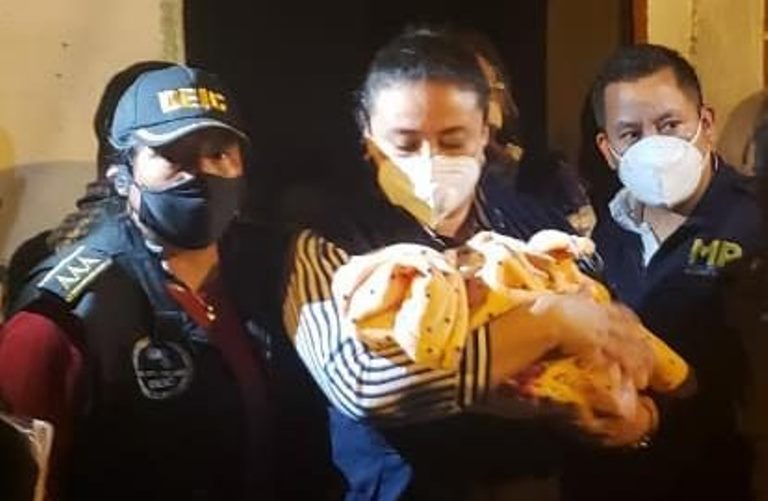 Agentes resguardan a la bebé rescatada.
