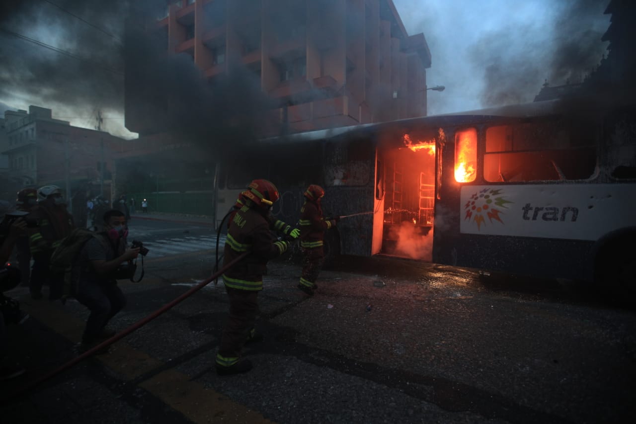 Encapuchados irrumpen la paz de la manifestación del 28 de noviembre, queman un bus y agreden a agentes de la PNC. Fotografía. Prensa Libre (Carlos Hernández). 