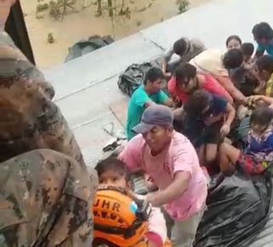 Personal del Ejército rescata a una familia en Izabal, que durmió en el techo de su casa inundada. (Foto Prensa Libre: Ejército de Guatemala)