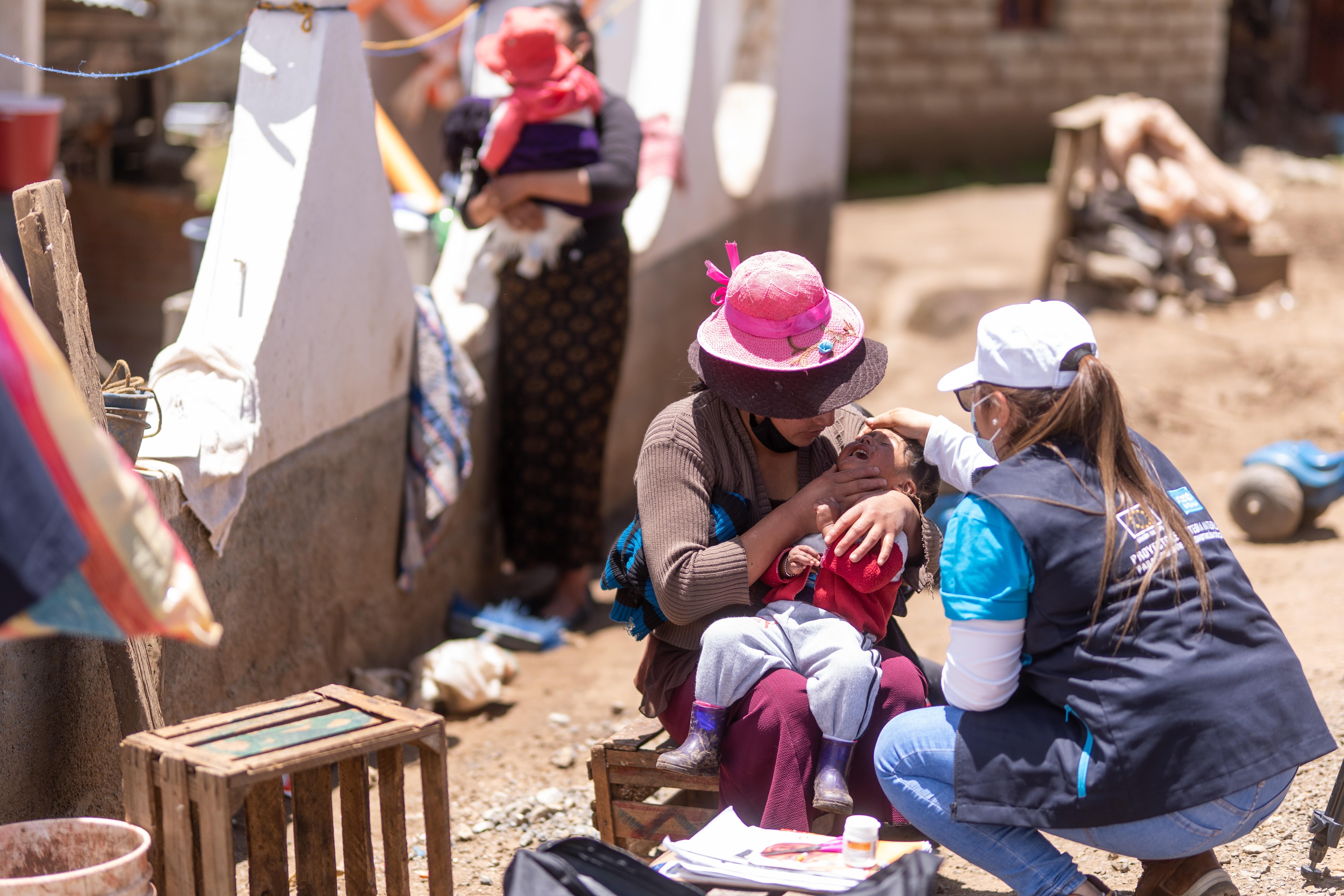 Fotografía sin fechar cedida por Unicef que muestra a brigadistas mientras revisan el ancho del brazo a un niño, para observar si sufre de desnutrición aguda, en la aldea Cuatro Caminos Cibilá, Chiantla. (Foto Prensa Libre: EFE)