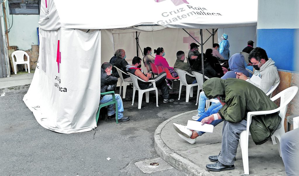 Varias personas esperan su turno para que les realicen el hisopado y descartar el contagio de covid-19 en la emergencia del Hospital General San Juan de Dios. Foto: Esbin García