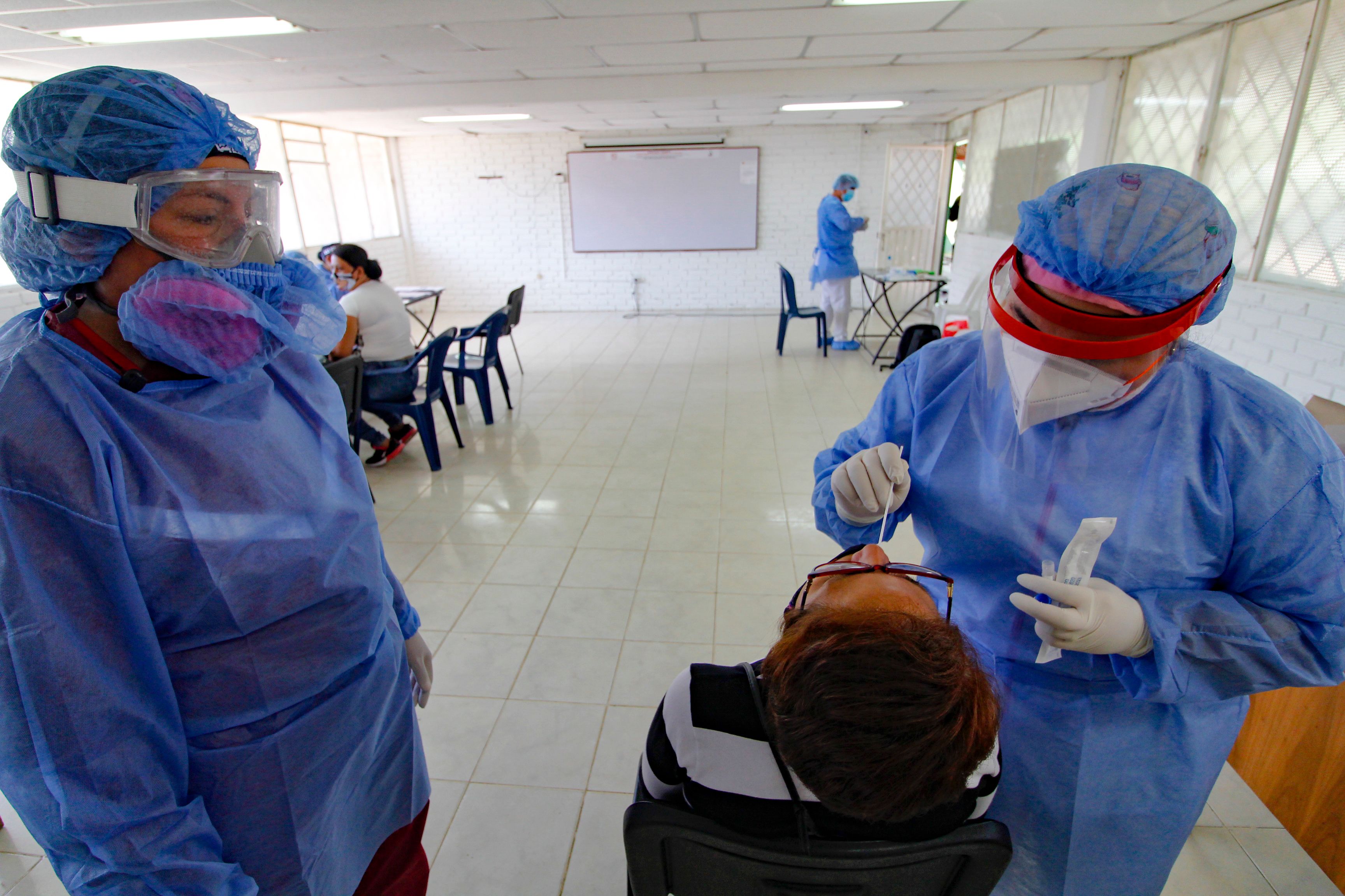 Un trabajador de Salud efectúa una prueba de covid-19 en un hospital fronterizo con Colombia. (Foto Prensa Libre: AFP)