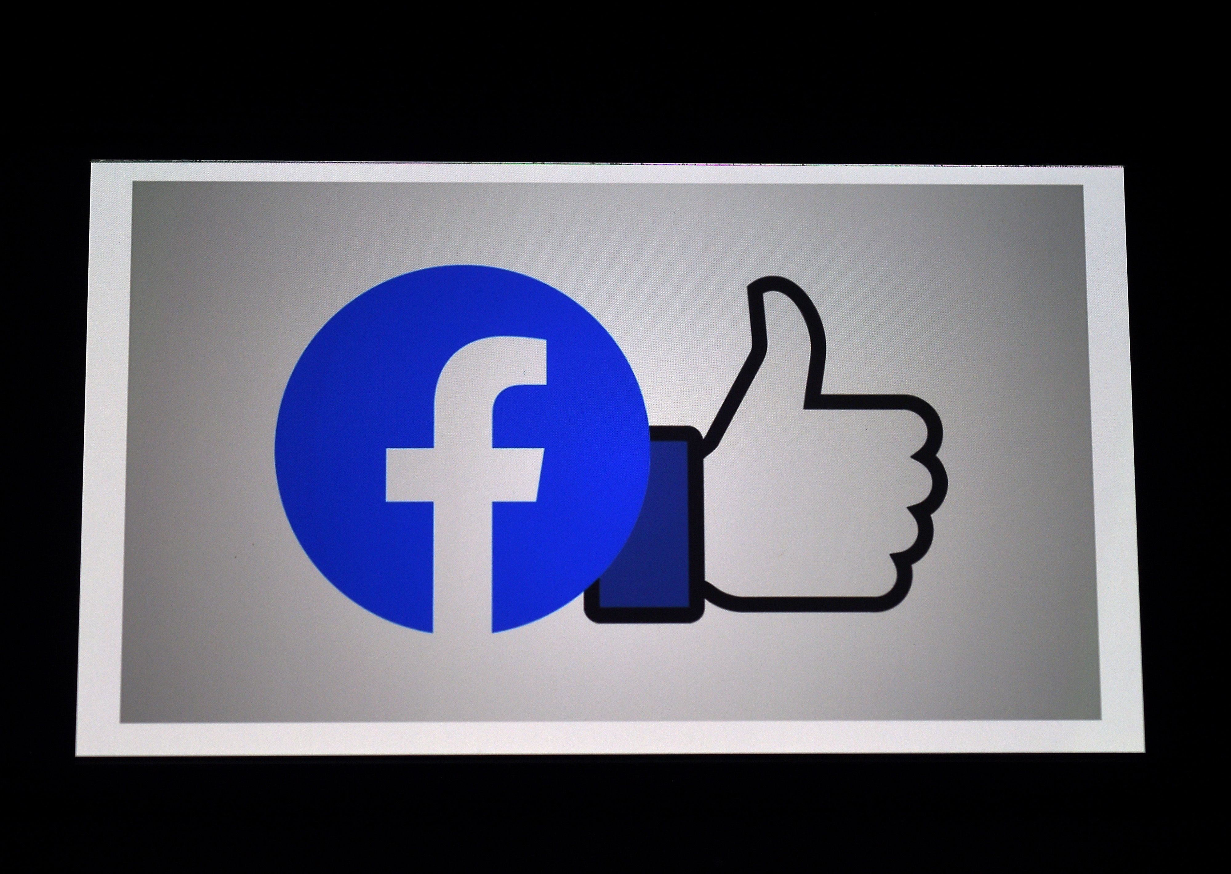 (FILES) In this photo illustration a Facebook App logo is displayed on a smartphone on March 25, 2020 in Arlington, Virginia. - Facebook confirmed on December 30, 2020 it was closing its Irish subsidiaries at the center of a dispute on profit shifting to avoid taxes in the United States. (Photo by Olivier DOULIERY / AFP)