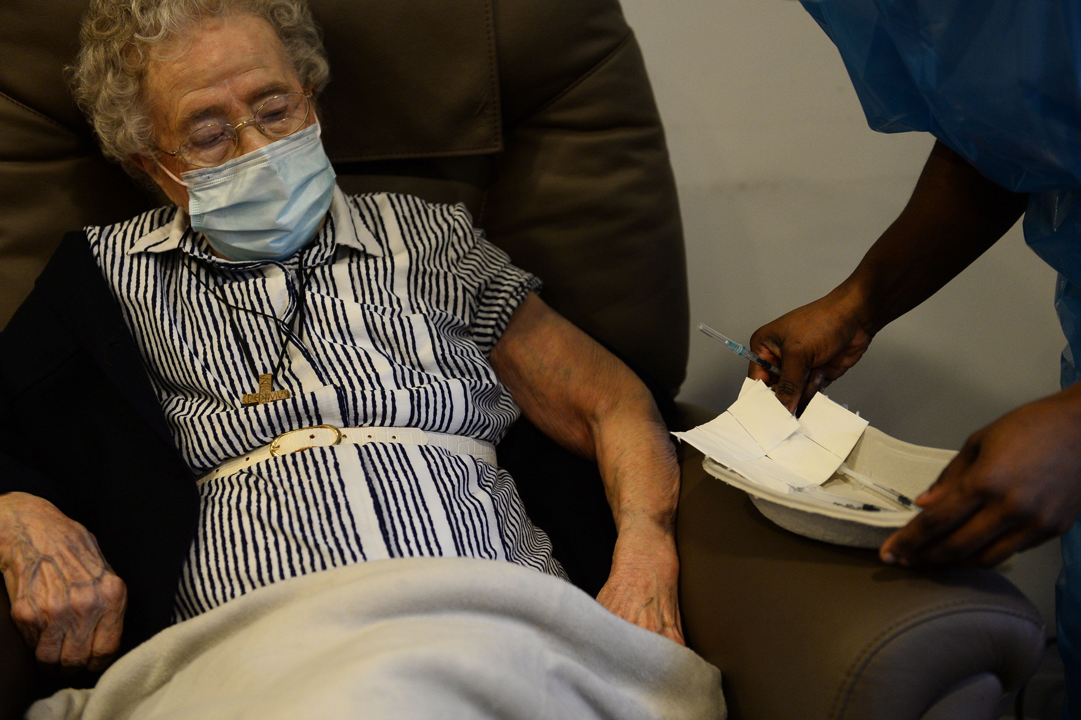 Lucie Danjou, belga de 101 años, recibe una dosis de la vacuna Covid-19 de Pfizer/BioNtech, mientras continúa el brote de la enfermedad en Bruselas (Bélgica), el 28 de diciembre de 2020. (Foto Prensa Libre: EFE)