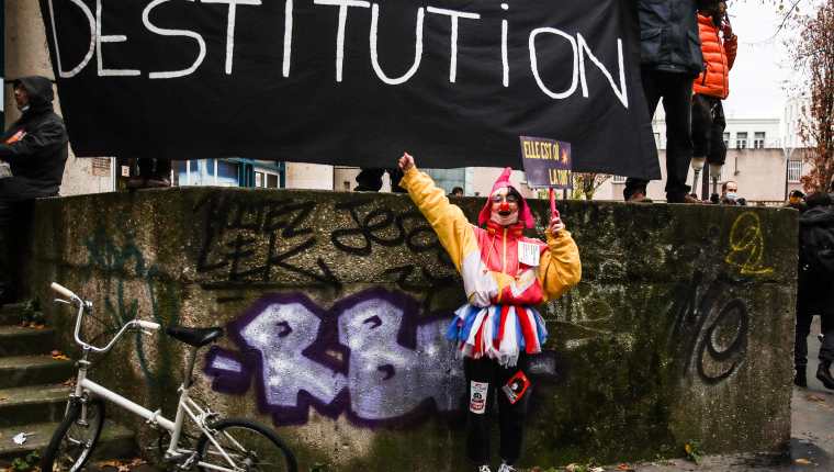Un manifestante disfrazado de payaso junto a un cartel que dice 'despido' en una protesta contra la controvertida ley de seguridad global de Francia. (Foto Prensa Libre: EFE)
